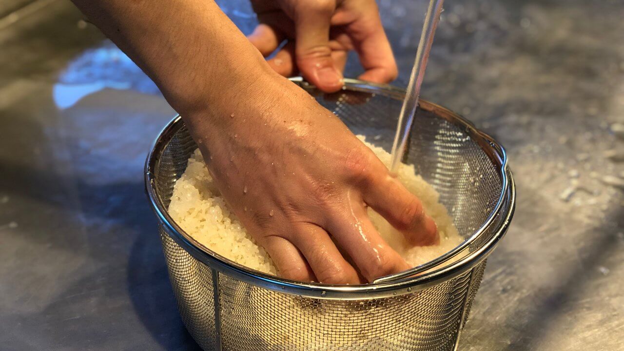 炊事場で米とぎ